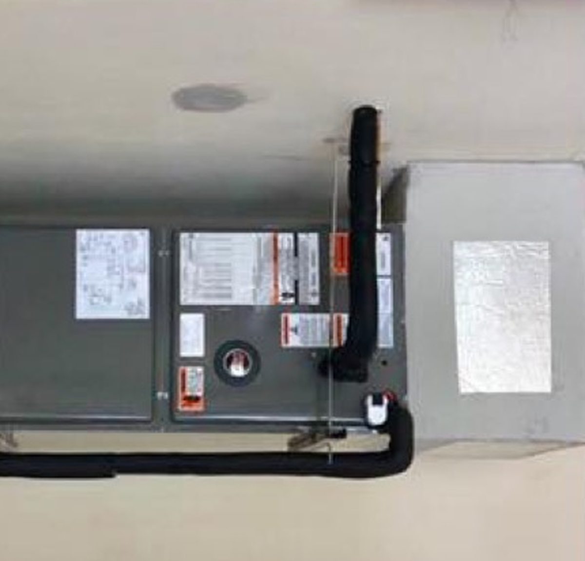 A permitted air handler installation with insulated line set and clean drain routing.